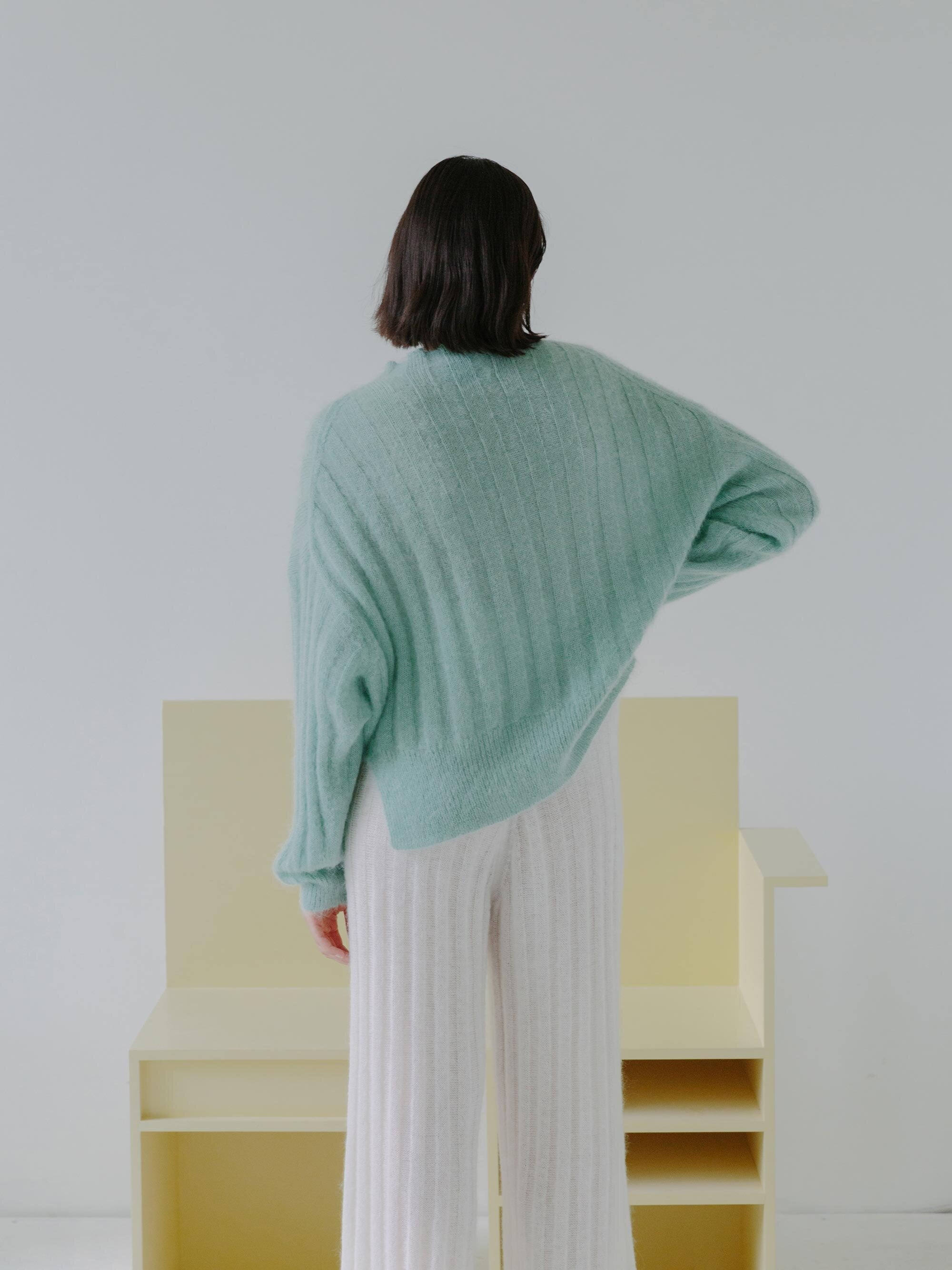 Esra wearing the MAKURA sweater and SHOJI pants with chairs N02F006 and N02F002. Photographed by Marina Denisova.