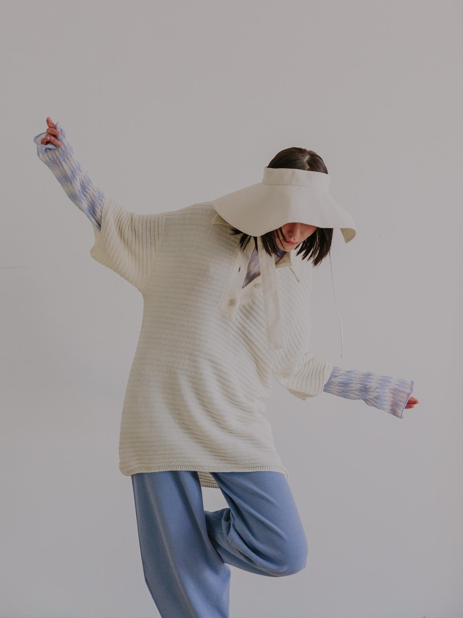 MIRAGE hat and JISHO polo in Eggshell, KUMO sweater and GIVRE pants in Pale Blue.